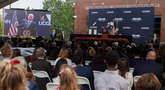 President Joe Biden speaking to an audience seated on the patio outside the Dodd Center for Human Rights on the UConn campus.