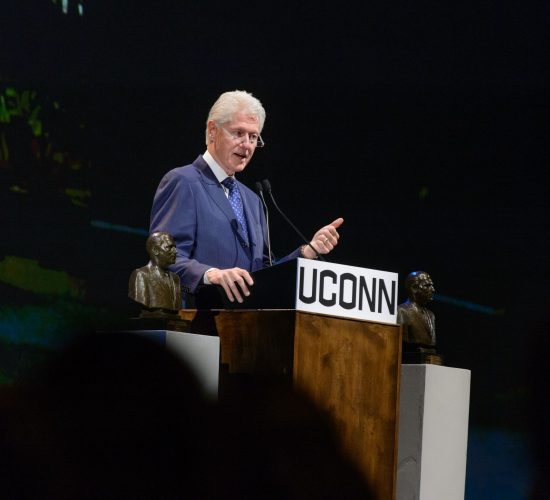 Former President Bill Clinton speaking at a podium at a Dodd Prize event