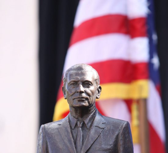 Dodd Prize award bust statue with an American flag in the background