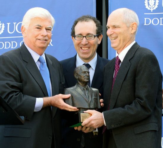 Senator Christopher Dodd awarding the Dodd Prize statue to two award recipients