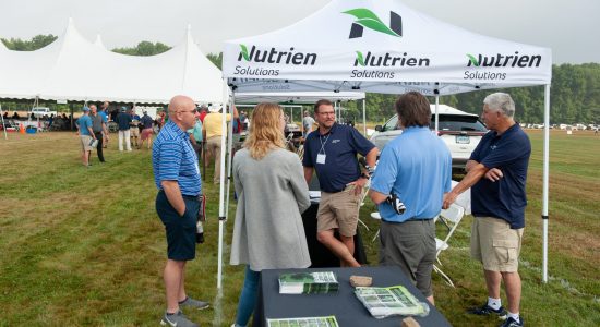 People chatting with a company representative at an outdoor booth during the 2022 UConn Turfgrass Conference