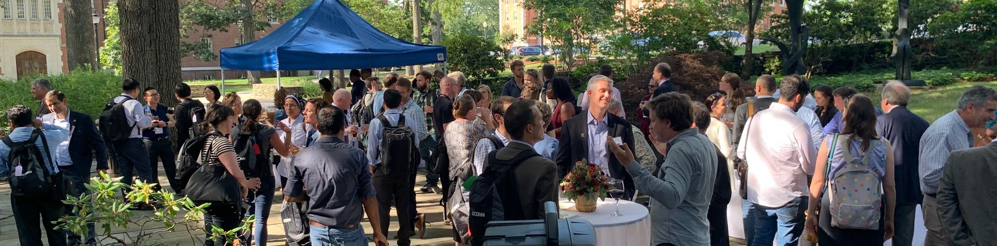 UConn faculty and administrators mingling on the Benton Museum outdoor patio at an early fall welcome event 