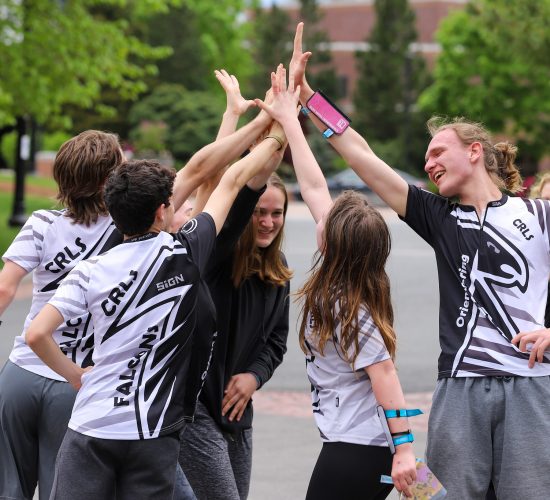 group of people in running attire high fiving