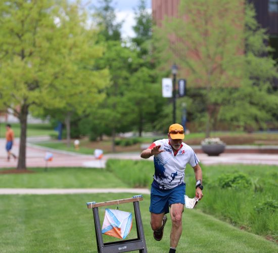 Runner running on a campus lawn